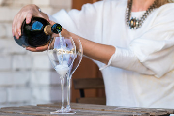 Woman pouring champagne in glasses