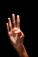 Hand figuring number 4 with fingers, isolated on black background.