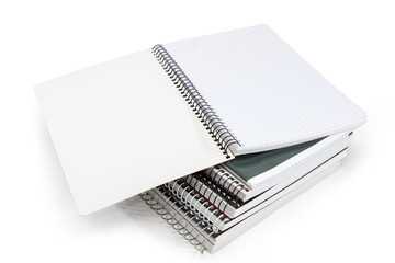 Open exercise book on stack of other exercise books