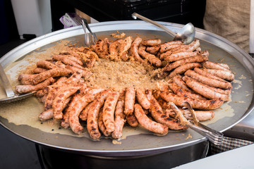 Sausages and sauerkraut cooked in a large pan. Street food.