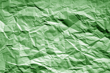 Crumpled sheet of paper with blur effect in green tone.