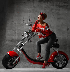 Obraz na płótnie Canvas 7186479 Woman ride new electric car motorcycle bicycle scooter pinup retro style in red blouse and jeans