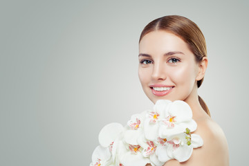 Fototapeta premium Beautiful young woman with white orchid flower on banner background