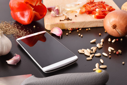 Preparation of vegetables on black wooden table with mobile elevated