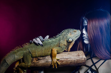 dead face girl and green iguana. Halloween.