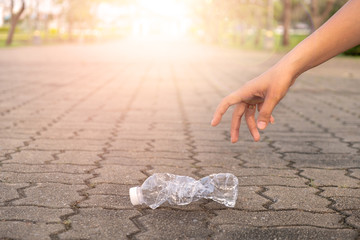 Hand picking up plastic bottle cleaning on the road