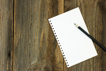 White cardboard and pencil on wooden desk 