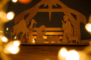 Christmas Nativity Scene of baby Jesus in the manger with Mary and Joseph in silhouette surrounded...