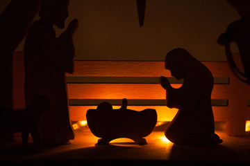Christmas Nativity Scene of baby Jesus in the manger with Mary and Joseph in silhouette surrounded...