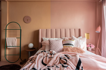 Cozy pink bedroom corner decorated with comfortable pink pillows and fluffy pink blanket setting on...