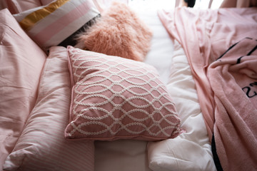 Top view of cozy bed with comfortable pink pillows and pink blanket in natural light scene in the...