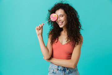 Portrait of caucasian woman 20s wearing casual clothing holding lollipop, isolated over blue background