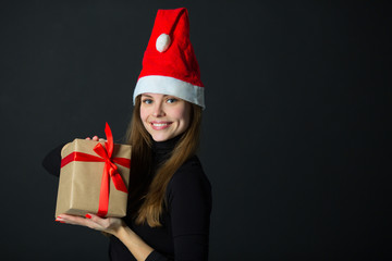 beautiful young girl with a gift in hand on a black background