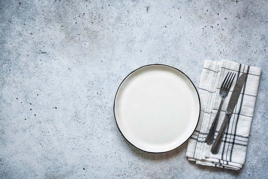 Table Setting Empty Plate And Cutlery On Concrete Background. Table Top View. Top View