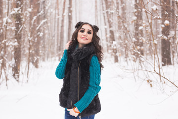 Fototapeta na wymiar Winter, season and people concept - Young pretty woman walking in snowy park
