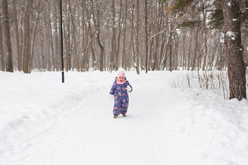 Fototapeta na wymiar Children, winter and nature concept - Close up of adorable kid playing with snow in the park