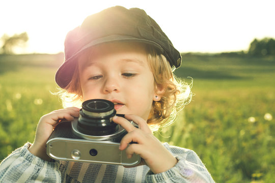 Portrait of a little girl taking pictures with a camera.Concept of children playing