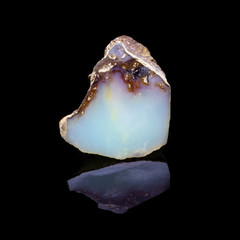 Natural polished opal stone on a black bacrground
