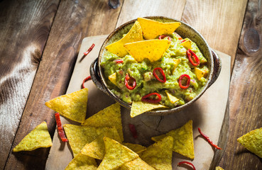 Bowl guacamole corn chips wooden table