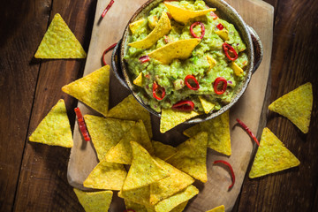 Bowl guacamole corn chips wooden table