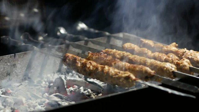Appetizing lula kebab grilled on metal skewer. Cooking meat.
