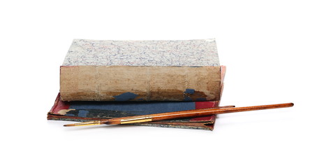 Old antique books and paint brush isolated on white background