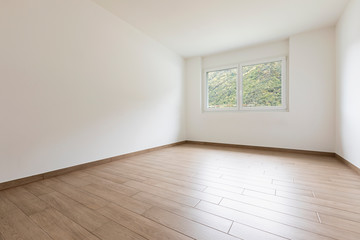 Empty room with white walls and window overlooking nature