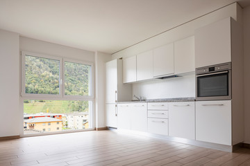 Living room with kitchen and large white wall