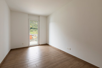 Empty room with white walls and window overlooking nature