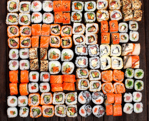 A variety of Sushi rolls on a wooden table