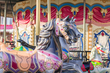 Vintage French colorful carousel in a holiday park. Merry-go-round with horses.