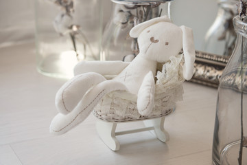 Toys newborns. White rabbit in a little buggy