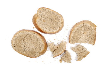 Integral bread slices with crumbs isolated on white background, top view