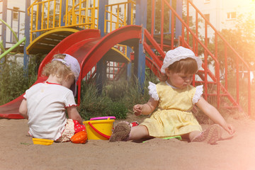 Two children playing in sandbox