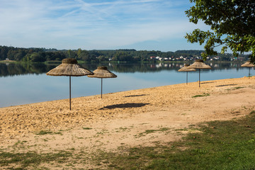 Umbrellas on the beach over the Brodzkie lake near Krynki, Swietokrzyskie, Poland