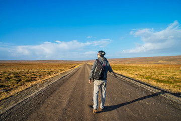 A man tourist walking on the gravel road in Iceland.