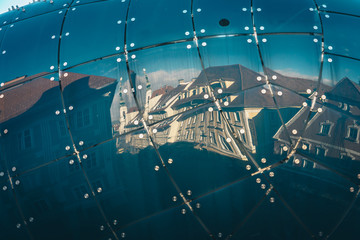 Graz city streets in the old town seen in the reflexion of Kunsthaus Museum facade