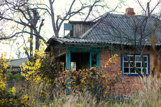 Old abandoned brick house among the autumn old garden