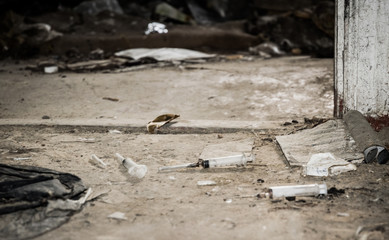 Old abandoned house and used plastic syringes. The problem of drug addiction in society