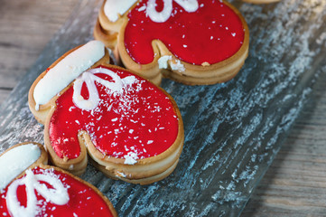 New year's dessert-cookies in the form of mittens of dough for pie and marmalade on a cozy Christmas table. Close up