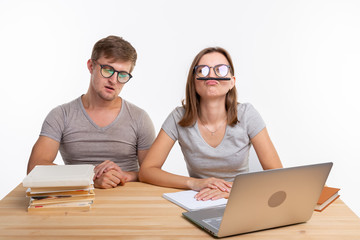 Education and people concept - a couple of young students in glasses look like they are bored of...
