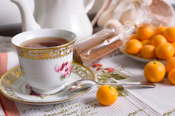 Decorative orange mandarins, tangerines, cup of tea, home mandarins, small mandarines.