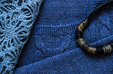 Fototapeta na wymiar Knitting and hand made concept-blue knitted sweater and black choker close-up. Knitting texture. Part of knitted clothing. Autumn, winter concept. Top view, copy space, flat lay.