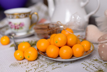Decorative orange mandarins, tangerines, cup of tea, home mandarins, small mandarines.