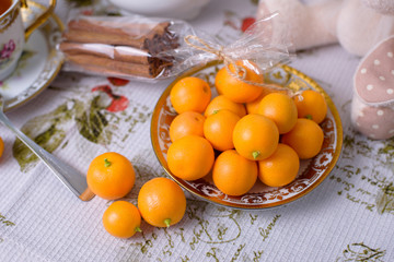 Decorative orange mandarins, tangerines, cup of tea, home mandarins, small mandarines.