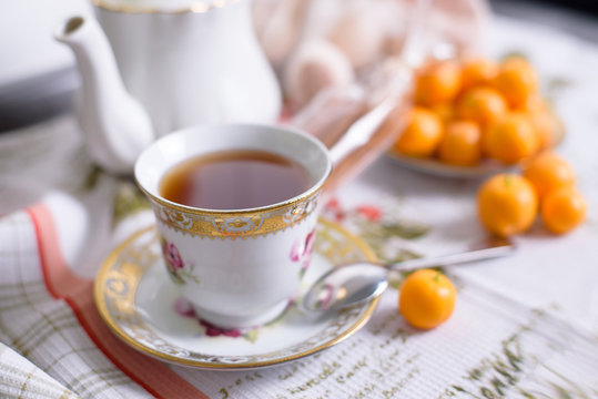 Decorative orange mandarins, tangerines, cup of tea, home mandarins, small mandarines.