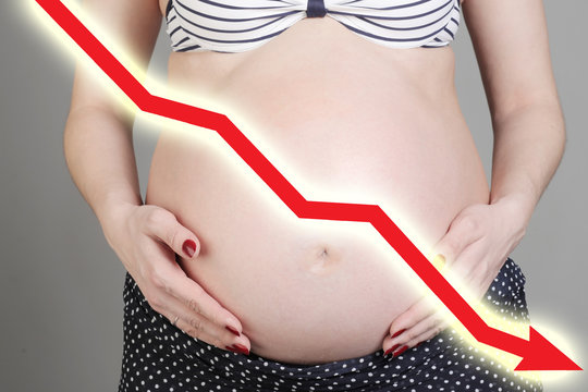 Pregnant woman and graph down; decrease of childbirth, concept