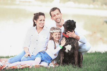 happy family with pet dog at picnic in a Sunny summer day. pregn