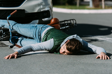 male bicycle rider hit by car on road, car accident concept