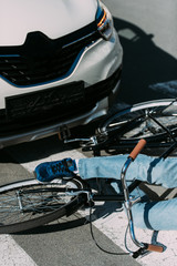 partial view of male bicycle rider hit by car on road, car accident concept